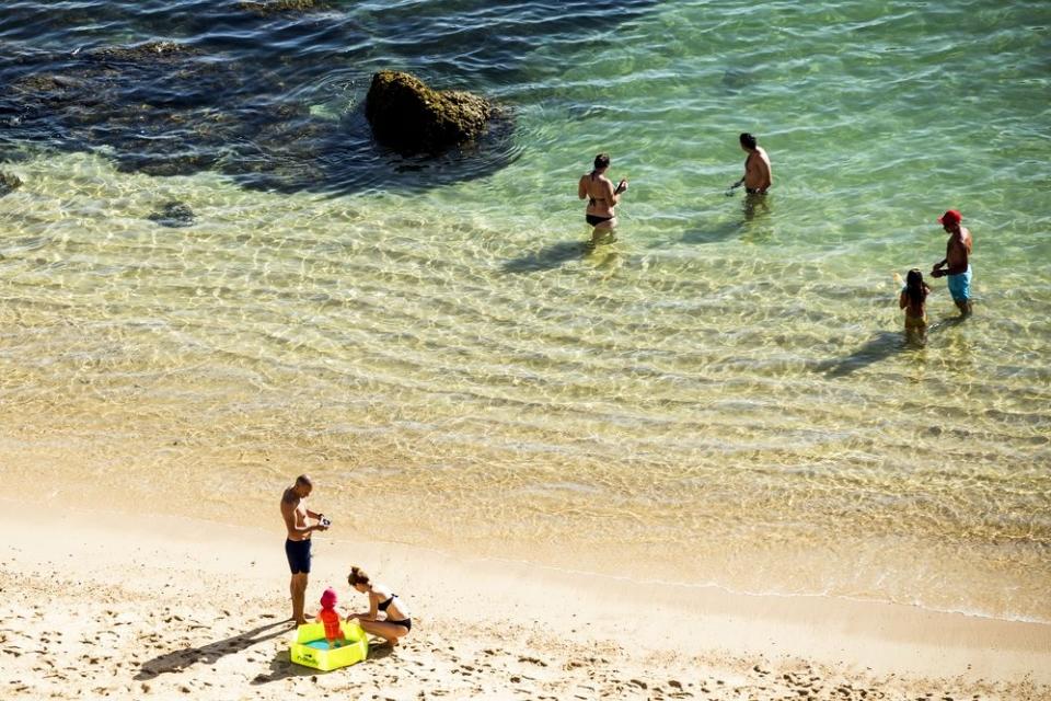 Banhistas que se queixam da água fria na praia do  Algarve